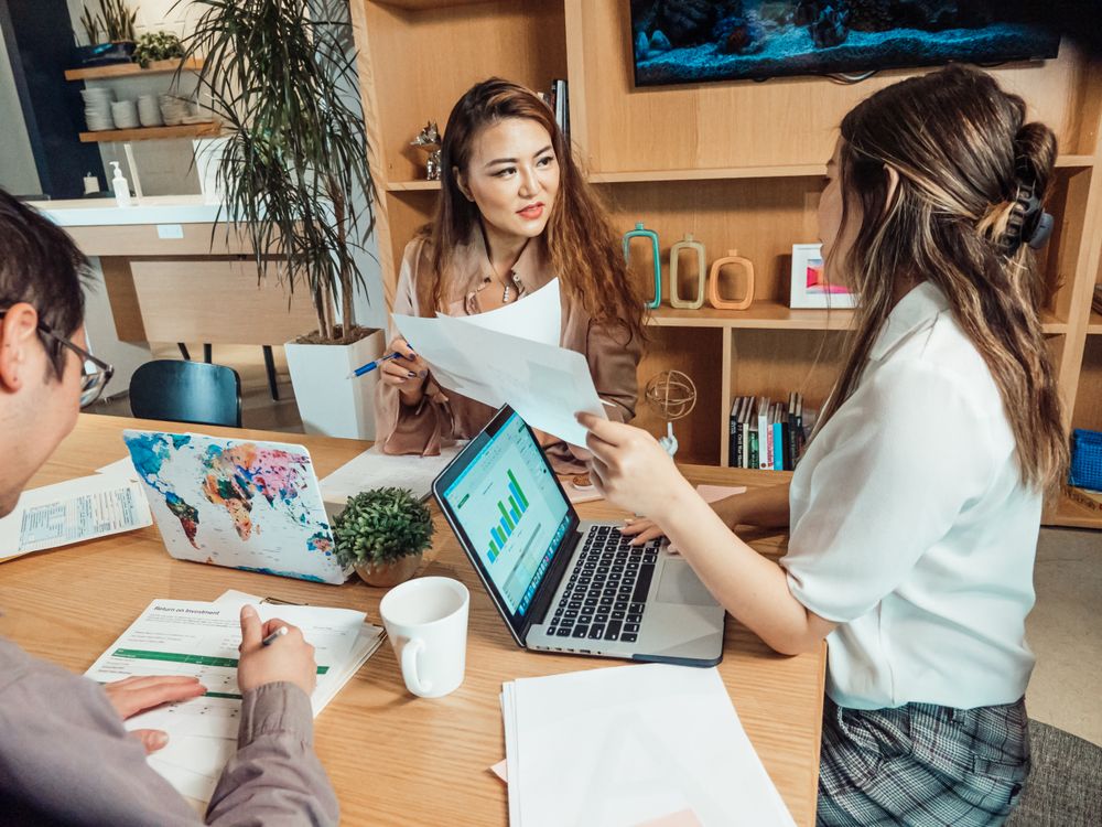 A small team reviewing work together around a table