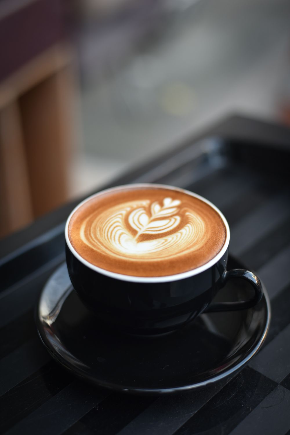 A barista finishing a careful latte-art pour